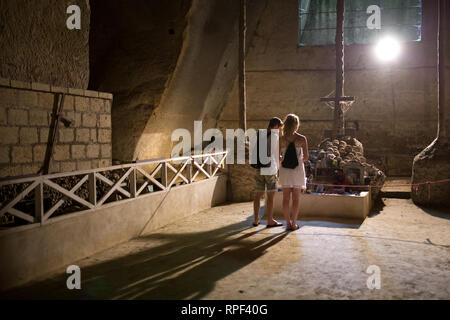 Neapel - Besucher vor einem Altar mit totenköpfen an der Fontanelle Friedhof geschmückt. Stockfoto