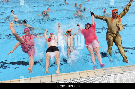 Karlsruhe, Deutschland. 22 Feb, 2019. Besucher des Open-air Swimming pool onnenbad' Sprung ins Wasser des Pools für die Eröffnung der Open-Air-Swimmingpool. Nach dem städtischen Schwimmbad Unternehmen, das Bad ist die erste Outdoor Pool in Deutschland zurück aus der Winterpause zu berichten. Egal wie kalt es ist: Sie können planschen und schwimmen außerhalb bei einer Wassertemperatur von über 28 Grad bis zum 1.Advent. Das Motto für die diesjährige Saison ist "Wer schwimmen außerhalb fit bleiben". Credit: Uli Deck / dpa/Alamy leben Nachrichten Stockfoto