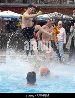 Karlsruhe, Deutschland. 22 Feb, 2019. Besucher des Open-air Swimming pool onnenbad' Sprung ins Wasser des Pools für die Eröffnung der Open-Air-Swimmingpool. Nach dem städtischen Schwimmbad Unternehmen, das Bad ist die erste Outdoor Pool in Deutschland zurück aus der Winterpause zu berichten. Egal wie kalt es ist: Sie können planschen und schwimmen außerhalb bei einer Wassertemperatur von über 28 Grad bis zum 1.Advent. Das Motto für die diesjährige Saison ist "Wer schwimmen außerhalb fit bleiben". Credit: Uli Deck / dpa/Alamy leben Nachrichten Stockfoto