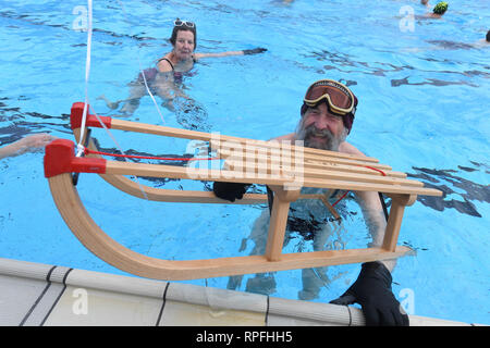 Karlsruhe, Deutschland. 22 Feb, 2019. Ein Besucher der Außenpool unbathing' ist das Wasser im Pool mit einem Schlitten für die Eröffnung der Außenpool. Nach dem städtischen Schwimmbad Unternehmen, das Bad ist die erste Outdoor Pool in Deutschland zurück aus der Winterpause zu berichten. Egal wie kalt es ist: Sie können planschen und schwimmen außerhalb bei einer Wassertemperatur von über 28 Grad bis zum 1.Advent. Das Motto für die diesjährige Saison ist "Wer schwimmen außerhalb fit bleiben". Credit: Uli Deck / dpa/Alamy leben Nachrichten Stockfoto