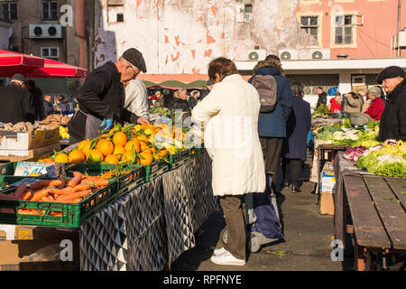 Zagreb, Kroatien - 29. Dezember 2018. Ein halter Stall dient einem Kunden an der Dolac frisches Obst und Gemüse im Zentrum von Zagreb Stockfoto