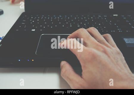 Des Menschen Hand mit schwarzer Laptop Touchpad, Trackpad verwenden, Drag & Drop, Gesten, Tastatur Stockfoto