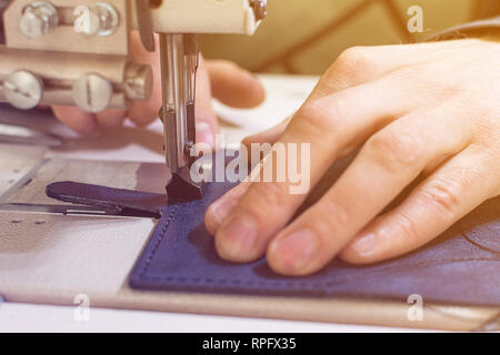 Professionelle Produktion Nähmaschine close-up, die Herstellung von Leder, Näherin, hand Schneider, getönt, hell, Licht Stockfoto
