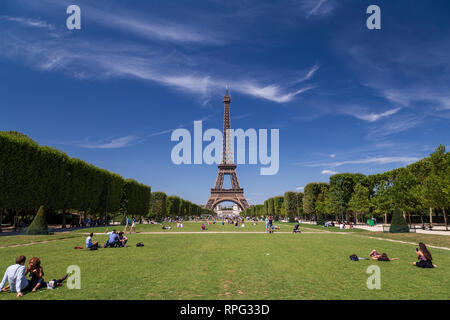 Leute genießen Sommer Wetter auf das Gras in Champ-de-Mars Park mit Blick auf den Eiffelturm in Paris, Frankreich Stockfoto