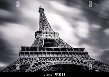 Blick auf den Eiffelturm von unten. Lange Belichtung mit Wolken im Himmel gestreckt. Schwarz und Weiß. Paris, Frankreich Stockfoto