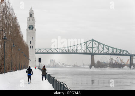 Montreal, CA - 21. Februar 2019: St. Lawrence River, Clock Tower und Jacques Cartier Brücke im Alten Hafen im Winter. Stockfoto