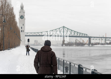 Montreal, CA - 21. Februar 2019: St. Lawrence River, Clock Tower und Jacques Cartier Brücke im Alten Hafen im Winter. Stockfoto