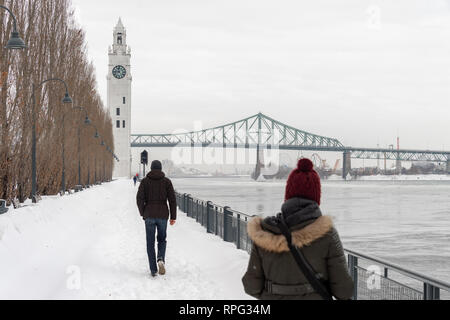 Montreal, CA - 21. Februar 2019: St. Lawrence River, Clock Tower und Jacques Cartier Brücke im Alten Hafen im Winter. Stockfoto