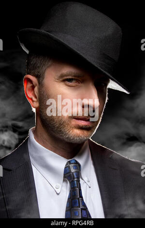 Mann mit einem fedora Hut als Film noir Detektiv oder Gangster posing Stockfoto