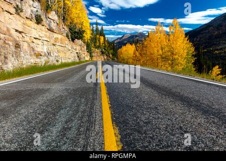 Herbst Straße mit der gelben Linie geht von Ouray zu Silverton Colorado, die 'Million Dollar Highway' mit Farbe, Route 550 Stockfoto