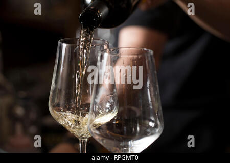 Nahaufnahme einer bardame dient zwei Gläser Prosecco an der Bar Cunter Stockfoto