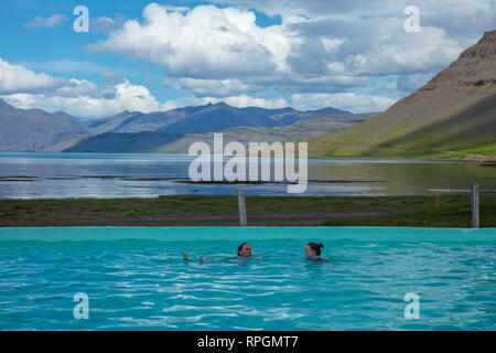 Outdoor Reykjafjardarlaug swimminers im geothermischen Pool, neben Arnarfjordur Fjord. Westfjorde, Island. Stockfoto