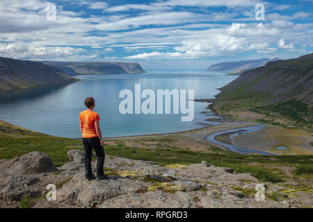 Person mit Blick über Arnarfjordur Fjord aus Nordfjall. Westfjorde, Island. Stockfoto