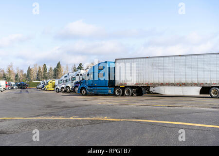 Big rigs kommerziellen Ladung Spediteure halb Lkw mit verschiedenen Auflieger verschiedener Marken und Modelle stehen auf LKW-Parkplätze für LKW-Fahrer Stockfoto