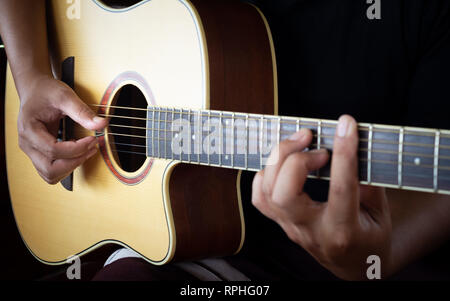 Des Menschen Hände spielen akustische Gitarre Stockfoto