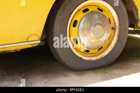 Reifen der alten gelben Auto auf dem Parkplatz Stockfoto