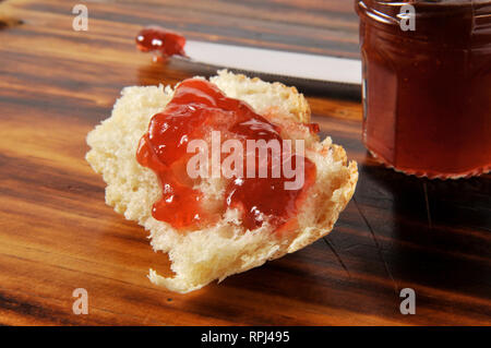 Ein Stück heiße frisch gebackenes Brot mit Marmelade auf einem Schneidebrett Stockfoto