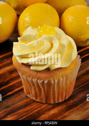 Nahaufnahme eines Cupcake mit Zitrone Glasur und frischen Zitronen Stockfoto