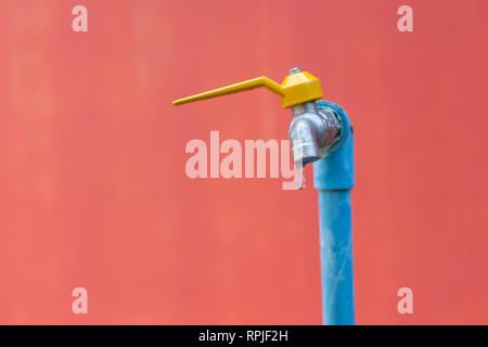 Wassertropfen Wasserhahn auf Mauer Hintergrund Stockfoto