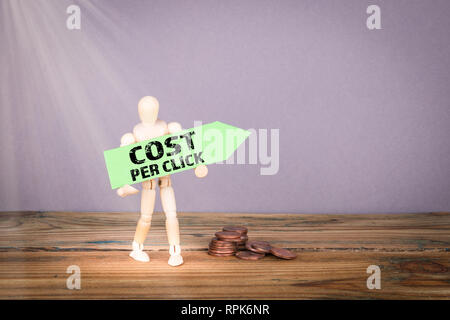 Kosten pro Klicken. Holz- Mann mit grünem Pfeil Stockfoto