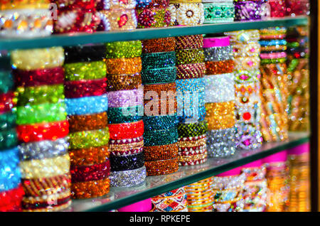 Eine Auswahl von schönen und bunten Glas Armreifen auf Anzeige zum Verkauf an laad Basar, Hyderabad, Telangana, Indien. Bokeh für kreative Wirkung verwendet. Stockfoto