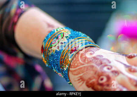 Eine Frau tragen Mehndi Design auf ihre Hand trägt ein Bündel von bunten/bunte Glas Armreifen an laad Basar, Hyderabad, Telangana, Indien gekauft. Stockfoto