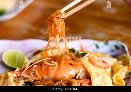 Ein Bild Show mit Essstäbchen mit gebratenen nooddle, sogenannte Pad Thai oder Thai fried nooddle mit Eiern und Garnelen Stockfoto