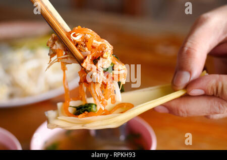 Ein Bild Show mit Essstäbchen mit gebratenen nooddle, sogenannte Pad Thai oder Thai fried nooddle mit Eiern und Lotus petal Stockfoto