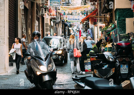 Neapel, Italien - 17. Oktober 2018: Mann, bei Scooter bei Vico Lungo del Gelso Straße. Verkehr auf berühmten engen Straße. Stockfoto