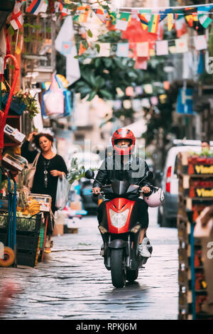 Neapel, Italien - 17. Oktober 2018: Mann Reiten auf einem Motorroller in der Via De deo Emanuele Straße. Verkehr auf berühmten engen Straße. Stockfoto