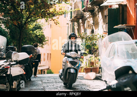 Neapel, Italien - 17. Oktober 2018: Mann, bei Scooter bei Vico S. Nicola Da Tolentino Straße. Stockfoto