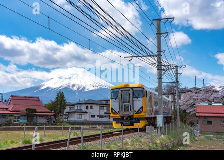 Fujikyu Bahn railroad Track mit Schnee bedeckten Berg Fuji (Mt. Fuji) Hintergrund in Kirschblüten Frühling. Fujiyoshida, Yamanashi, Japan Stockfoto