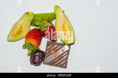 Erdbeeren, in Scheiben geschnitten Guave, Datum und Schokolade auf weißem Hintergrund. Stockfoto