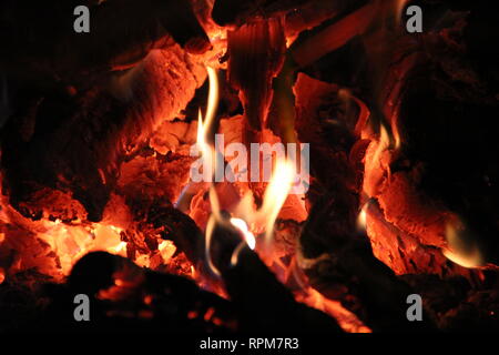 Flammen im Ofen beim Kochen in Gusseisen Tanks. Feuer im Ofen. Helle Flammen Stockfoto