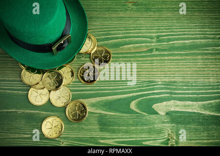 Happy St Patricks Day leprechaun hat mit Goldmünzen auf Vintage grün Holz Hintergrund Stockfoto