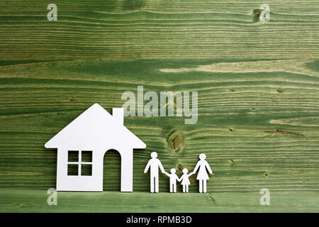 Familie Abbildung mit einem Haus auf hölzernen Hintergrund Stockfoto