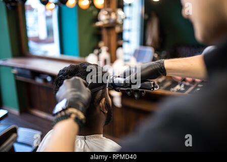 Die Hände der jungen Friseur Haarschnitt zu attraktiven Mann im barbershop Stockfoto