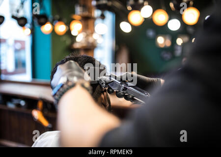 Die Hände der jungen Friseur Haarschnitt zu attraktiven Mann im barbershop Stockfoto