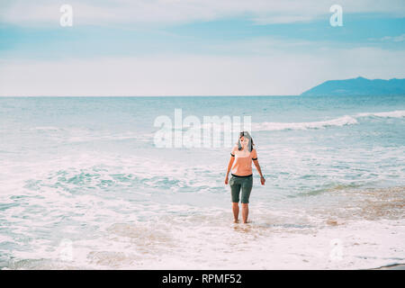 Glückliche Junge kaukasier Dame Frau Wandern im Sommer Meer Ozean Strand Stockfoto