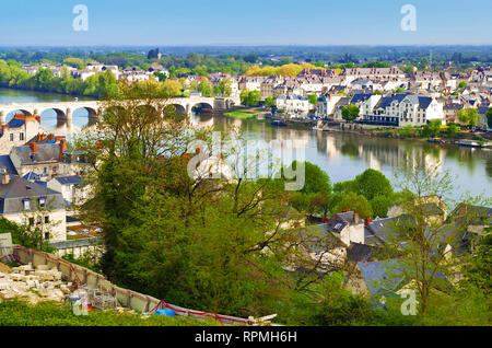 Atemberaubende Aussicht auf tolle kleine Stadt Saumur, Frankreich. Viele weiße und graue Häuser in der Nähe der Loire, bogenförmige Brücke, viele grüne Bäume und Dächer Stockfoto