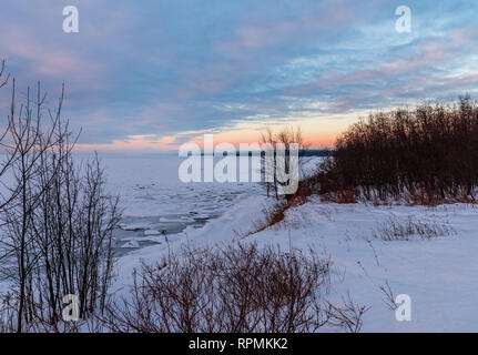 Bunte Wolken bei Sonnenaufgang auf vereisten Ufer des Lake Superior im Winter. Duluth, Minnesota, USA. Stockfoto