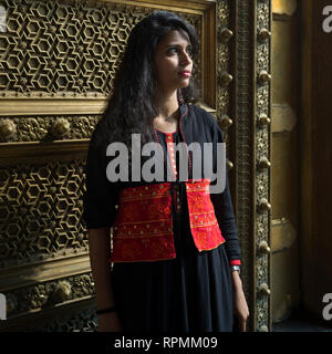Junge Frau steht vor einem reich verzierten Tür, City Palace, Jaipur, Rajasthan, Indien Stockfoto