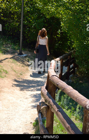 Junge Frau allein zu Fuß auf einem Wald Stockfoto