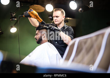 Close up Seitenansicht junger bärtiger Mann präparierten durch Friseur mit Fön bei Barbershop Stockfoto