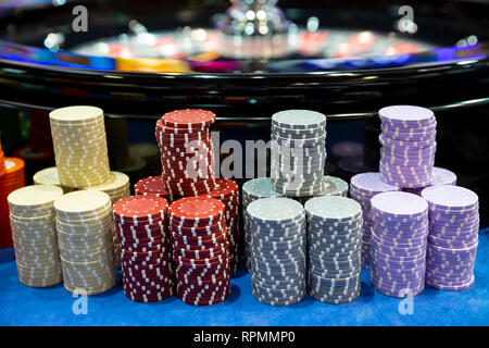 Bunte roulette Chips in ein Casino auf einem Spieltisch in der Nähe von Roulette Rad. Viele Chips mit verschiedenen Nominierung und Farben. Stockfoto