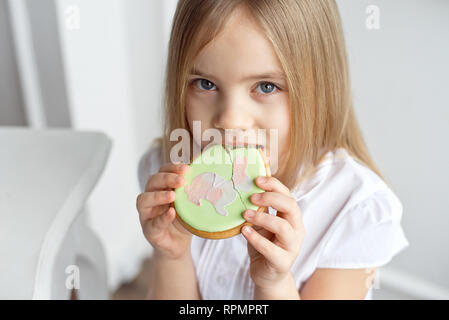 Close-up schöne Kind ißt, Lebkuchen Eier. Glückliche Familie Vorbereitung auf Ostern. Stockfoto