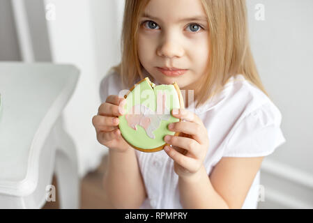 Close-up schöne Kind ißt, Lebkuchen Eier. Glückliche Familie Vorbereitung auf Ostern. Stockfoto