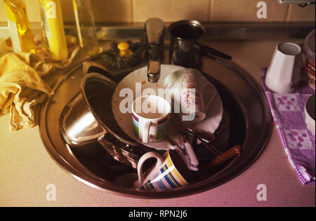 Details einer Küche Schreibtisch, ein Waschbecken voll mit schmutzigem Geschirr und Besteck. Stockfoto