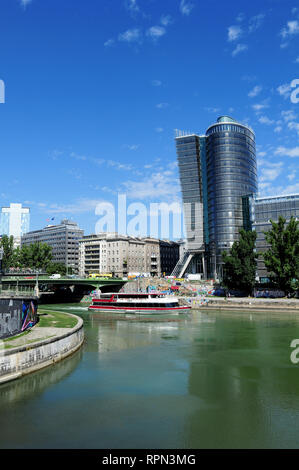 Bootstour entlang des Donaukanals (Donaukanal), in der Innenstadt von Wien, Österreich. Auf der anderen Seite des Flusses, die moderne Architektur der Uniqa Tower. Stockfoto