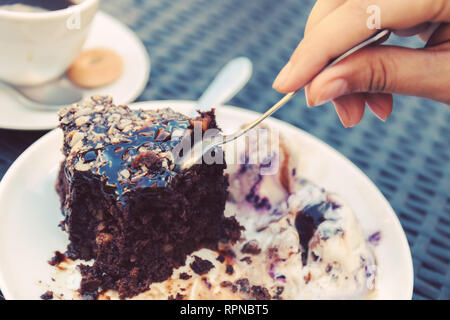 Brownie mit Eis. süß und Dessert. weibliche Hand mit einem Löffel trennt ein Stück Kuchen. Foto Stockfoto